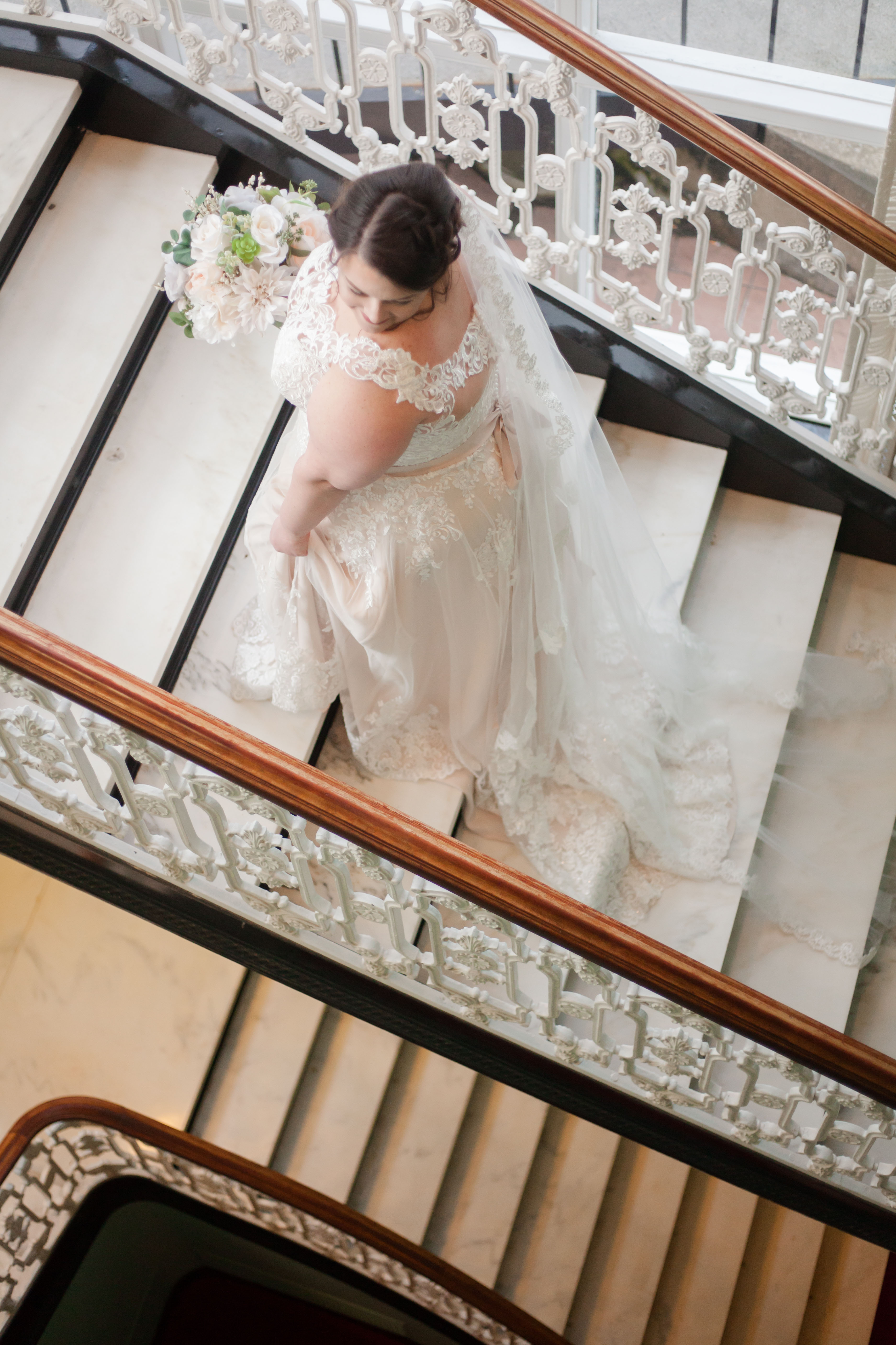 girl with brown hair in wedding gown going up stairs at greenbrier resort