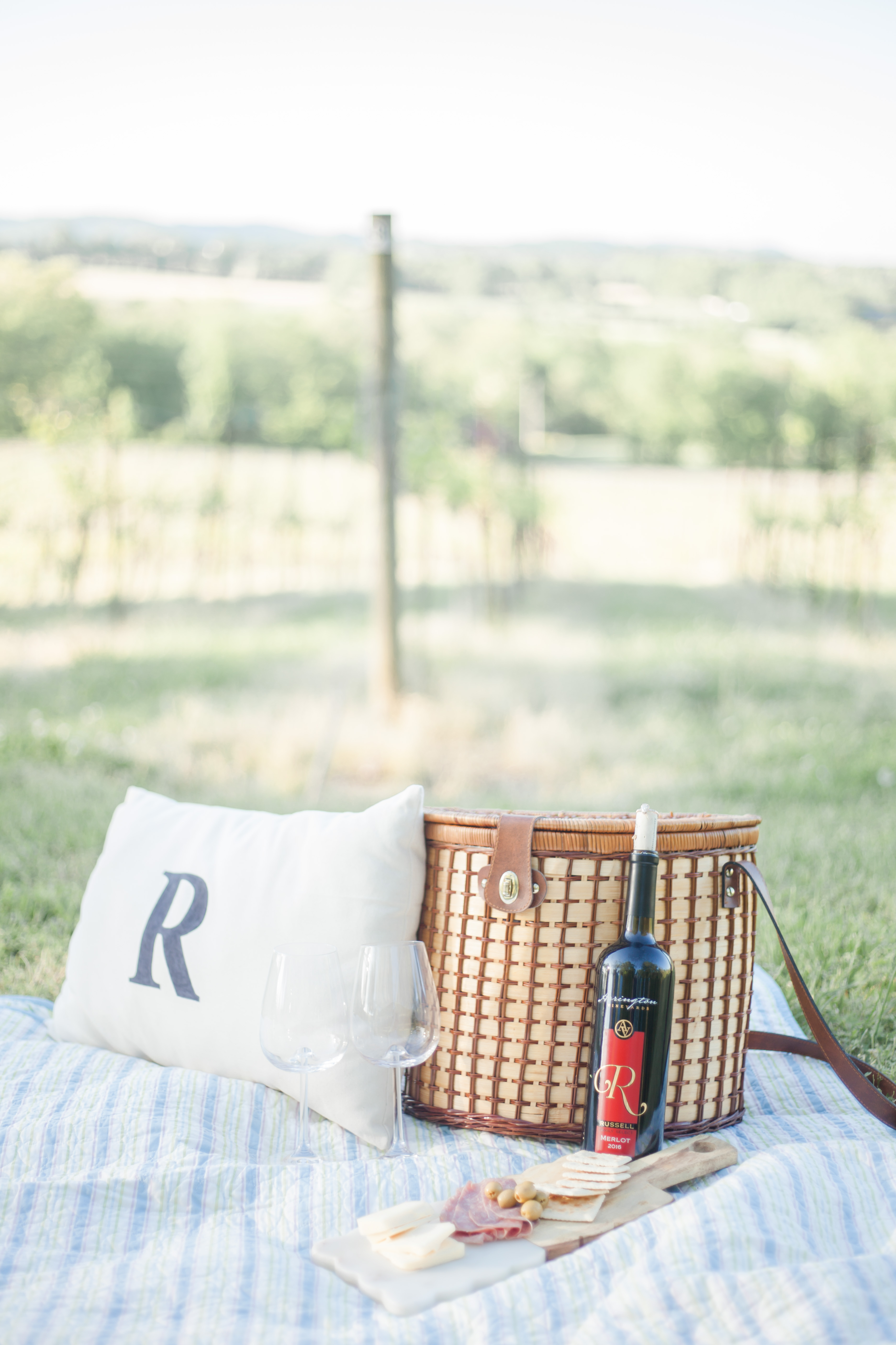 R monogrammed pillow and wine bottle with picnic basket