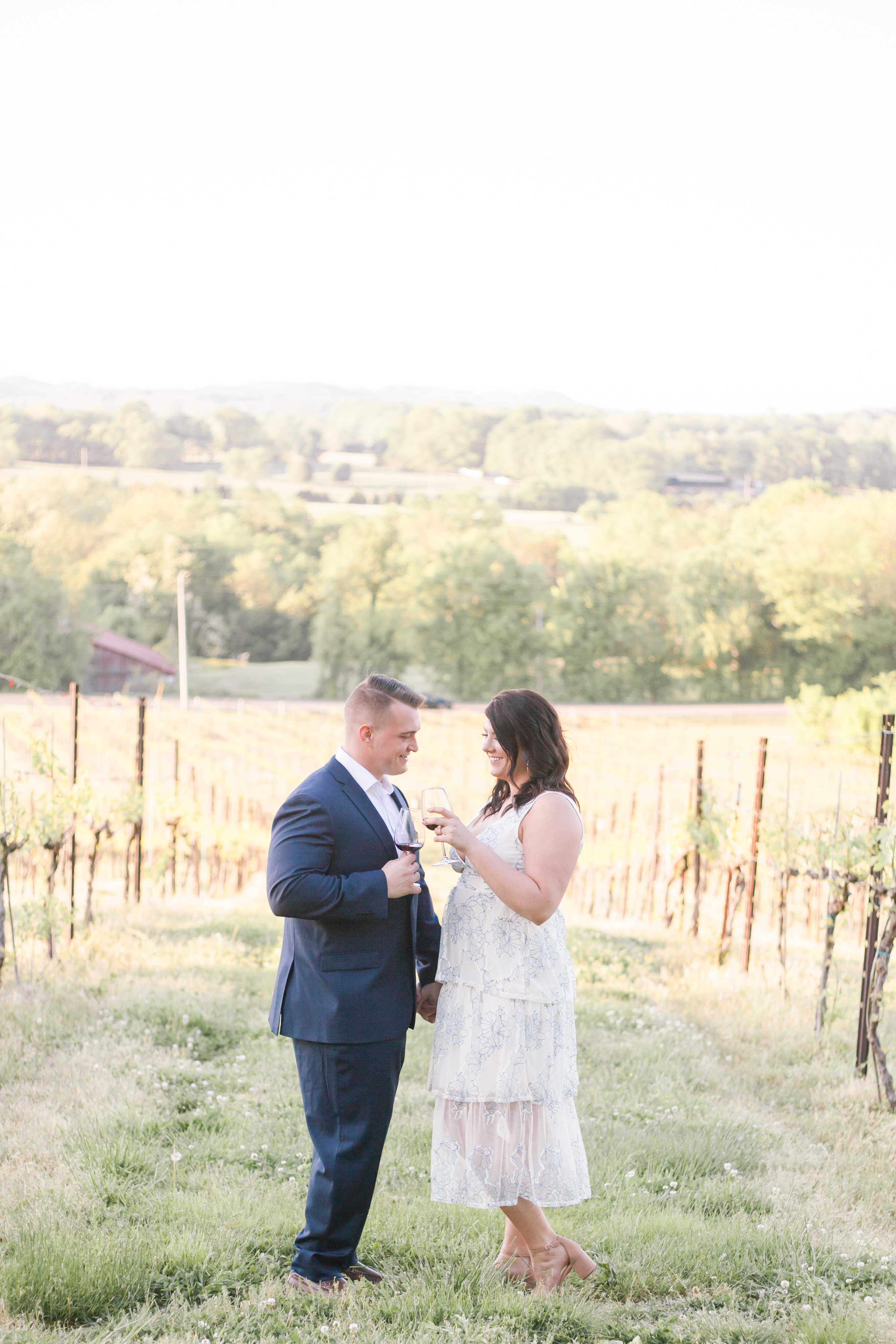 cute couple in vineyard with wine glasses