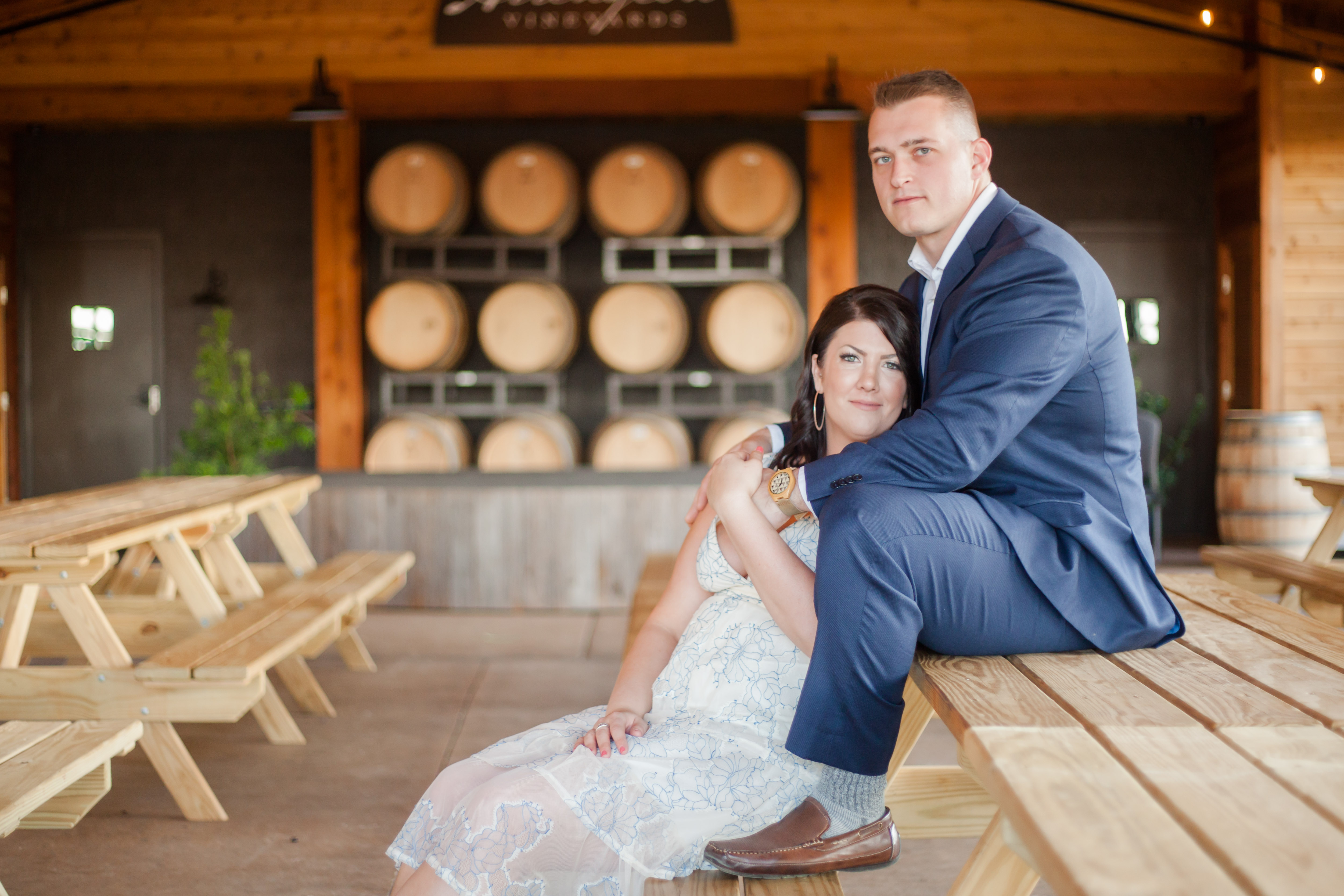 cute couple sitting with vineyard barrels