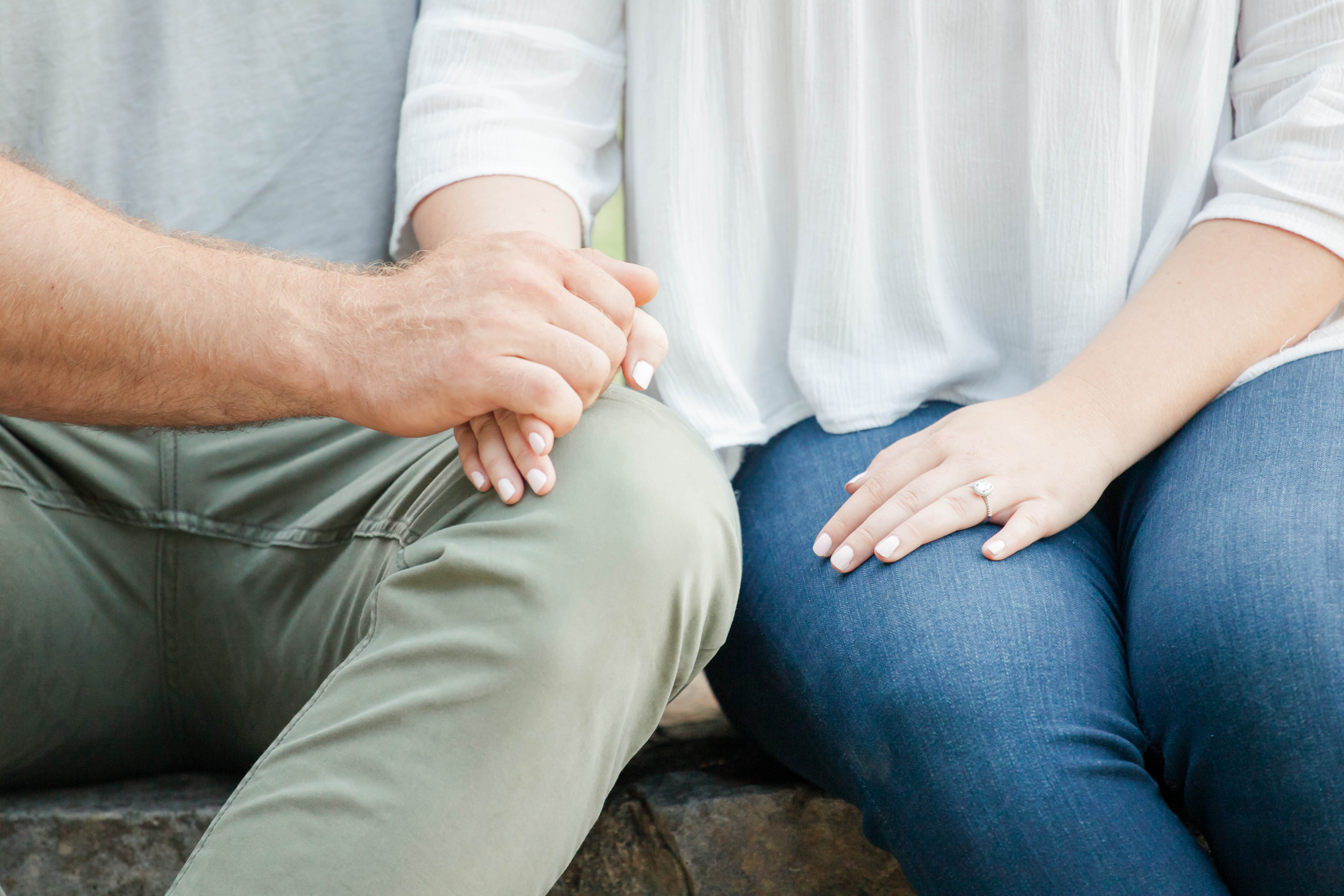 woman in blue jeans and man in green pants holding hands