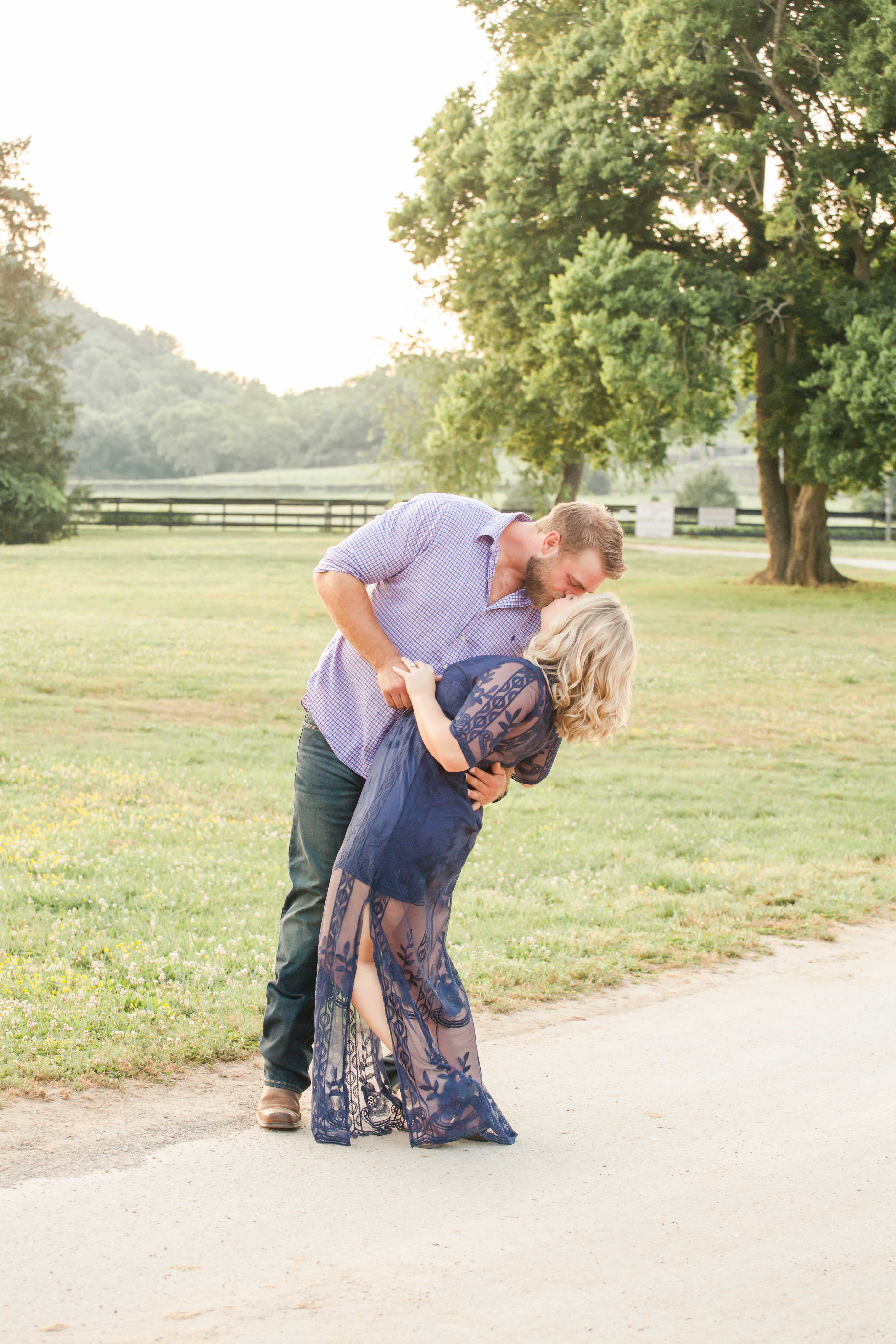 girl in navy lacy dress kissing guy in blue plaid button up