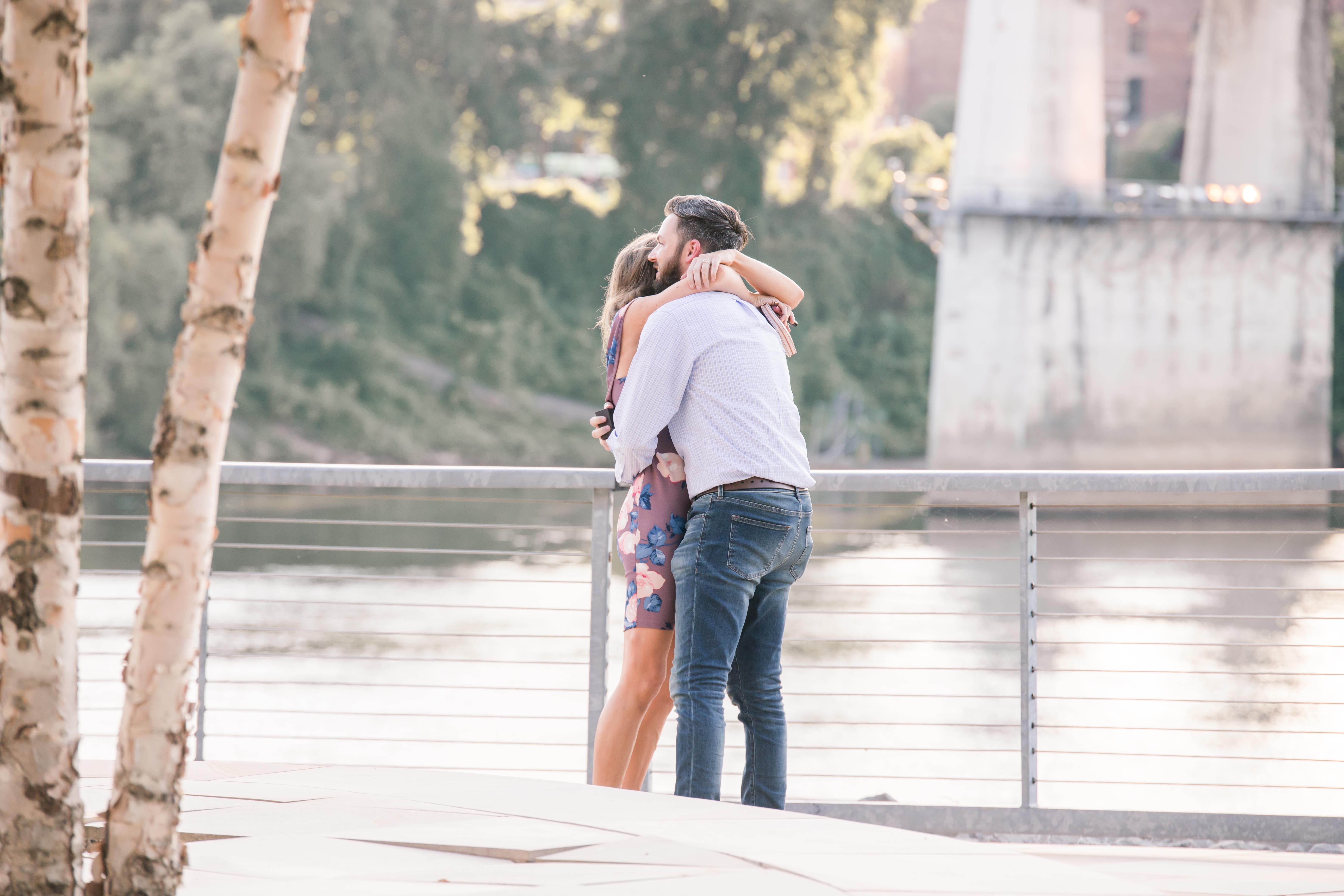 guy and girl hugging in front of nashville river