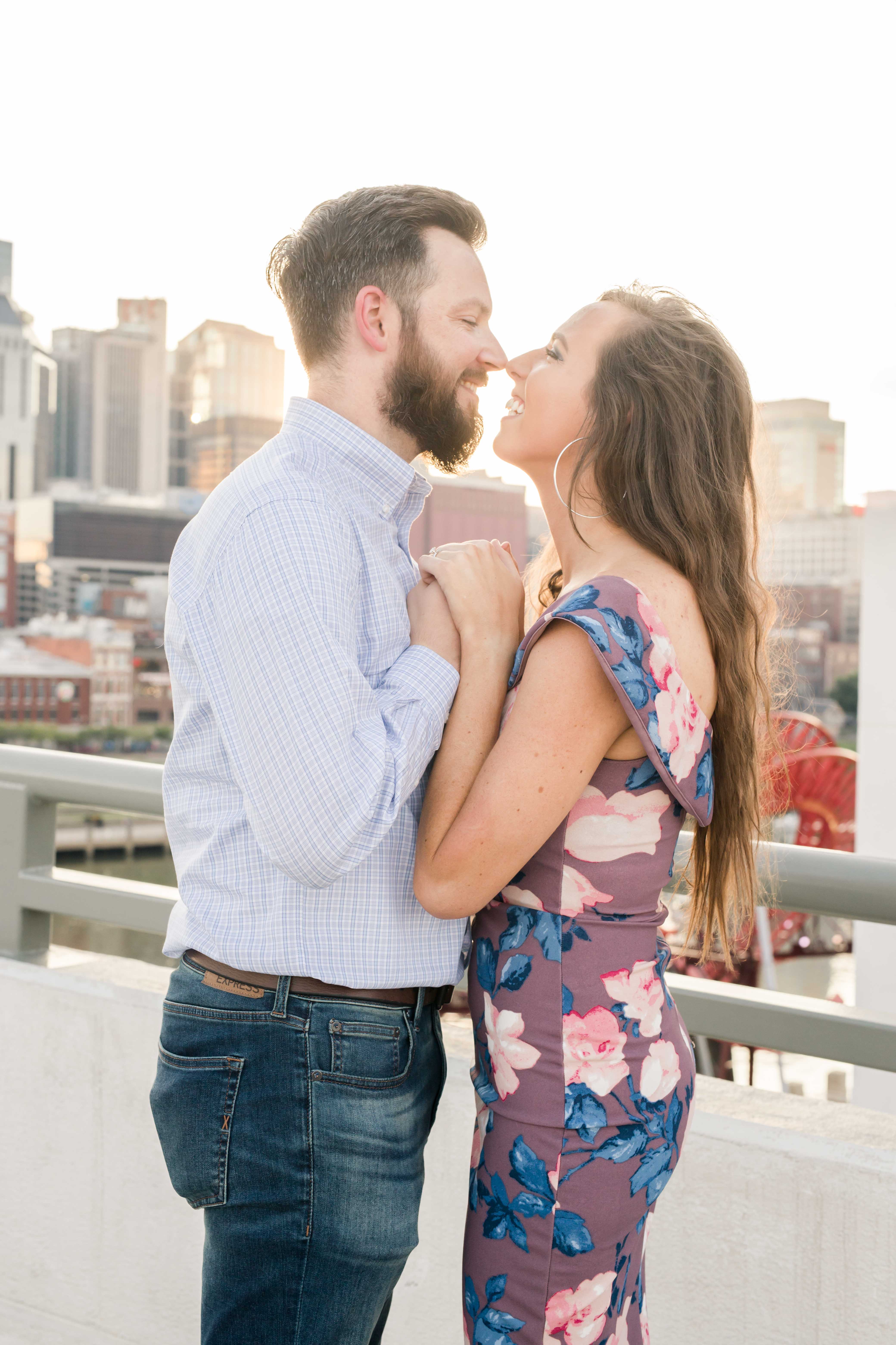guy in button down and girl in purple dress nuzzling noses