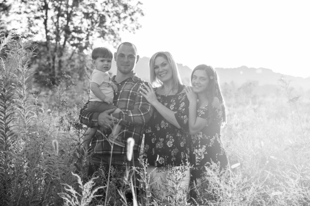 black and white family photo four people in a field