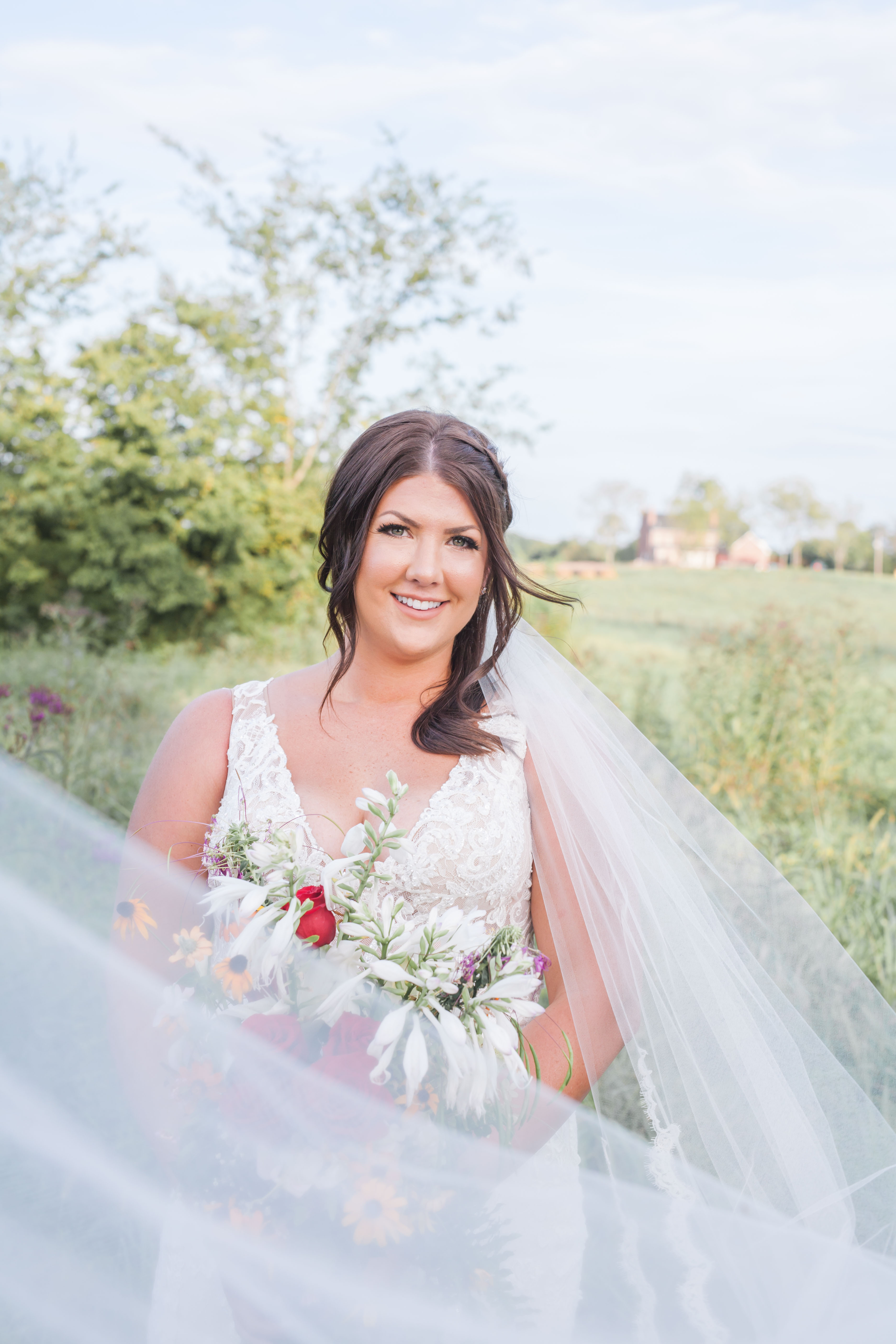 bridal photos bride with long veil holding flowers
