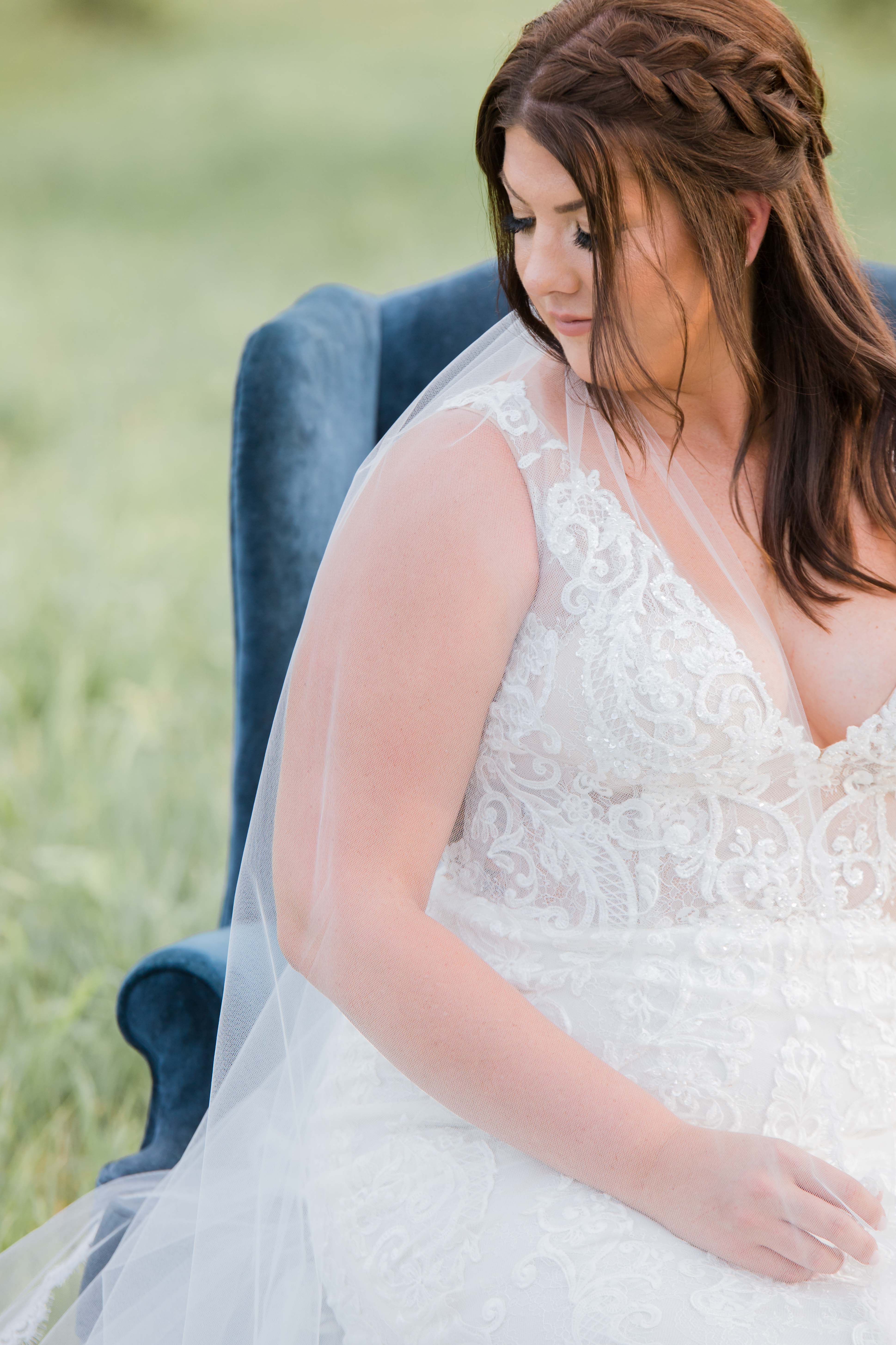 brunette bride with braid in hair on navy chair