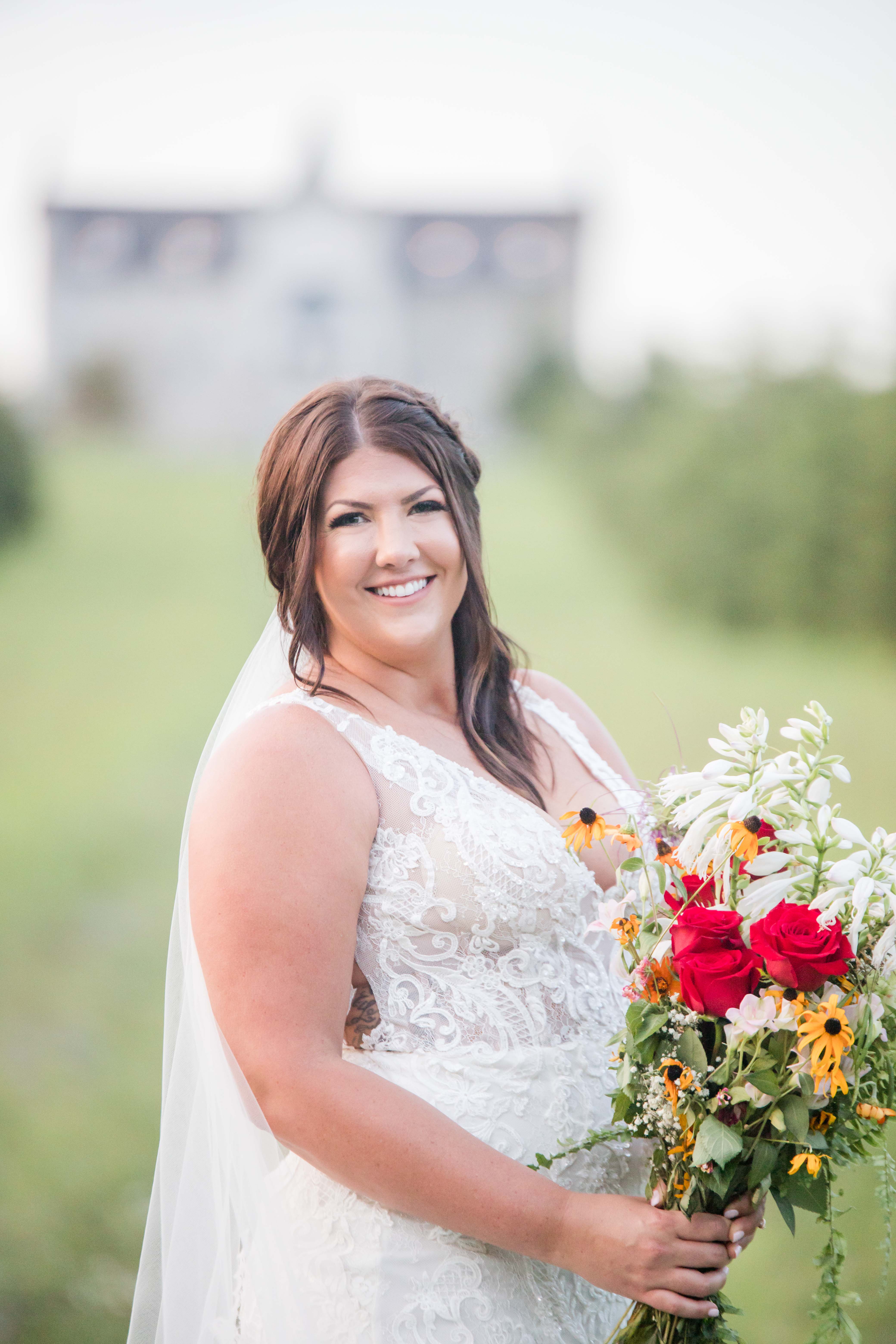 bride in front of castle holding flowers