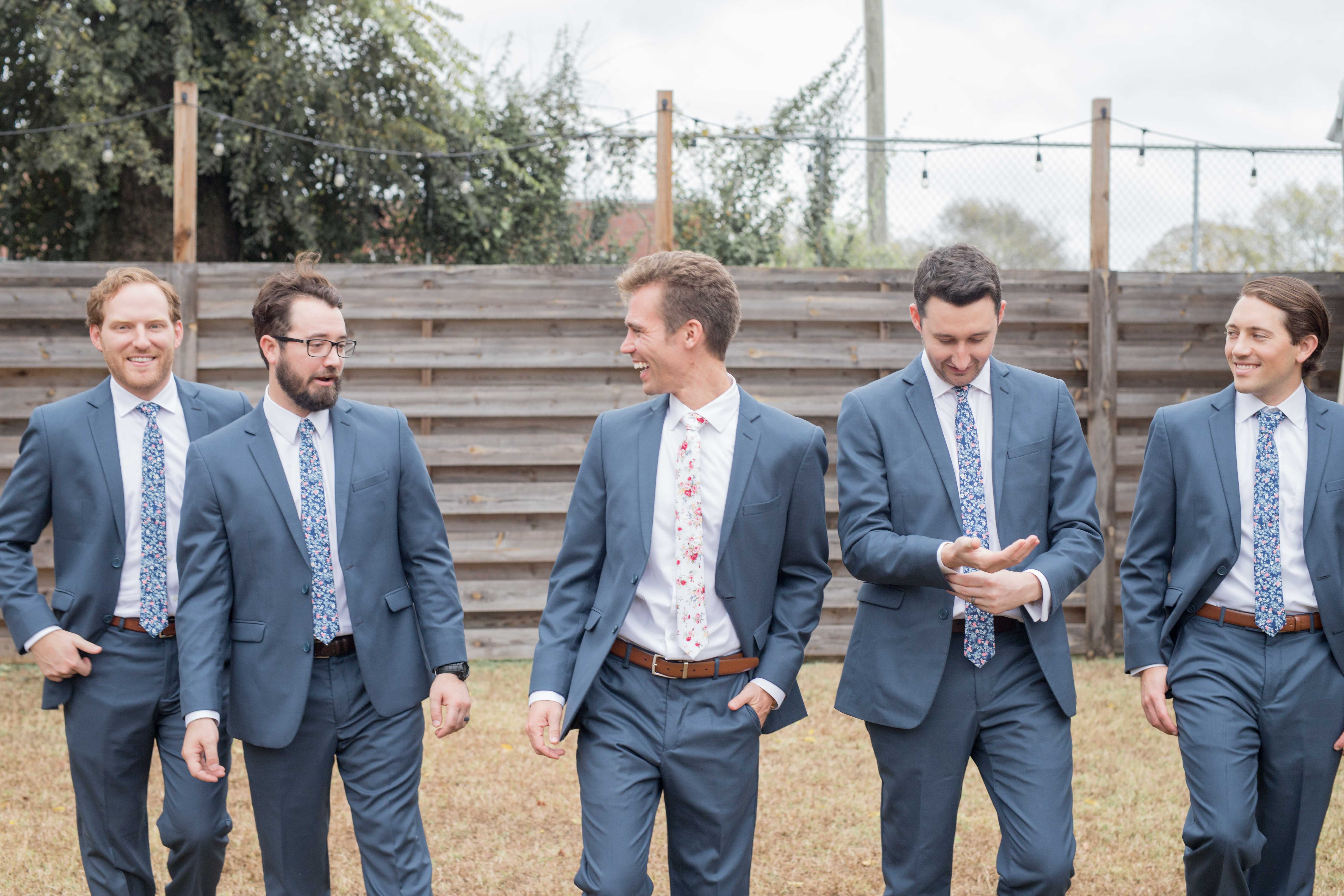 groomsmen in dark blue suits walking